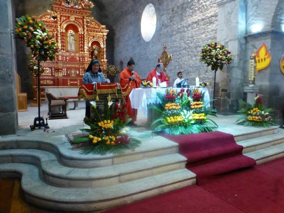 Lectura de la Palabra en el altar, junto a arreglos florales