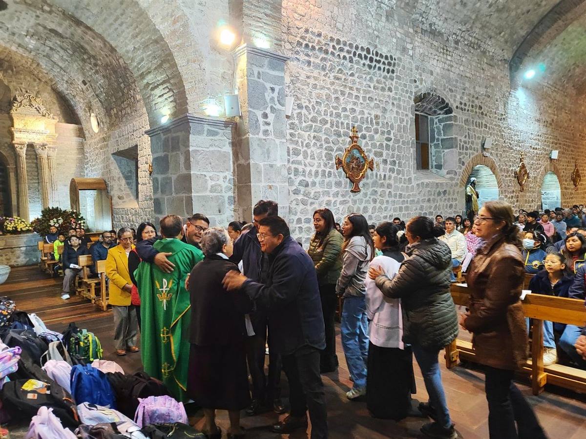 Familias con sus mochilas durante la bendición