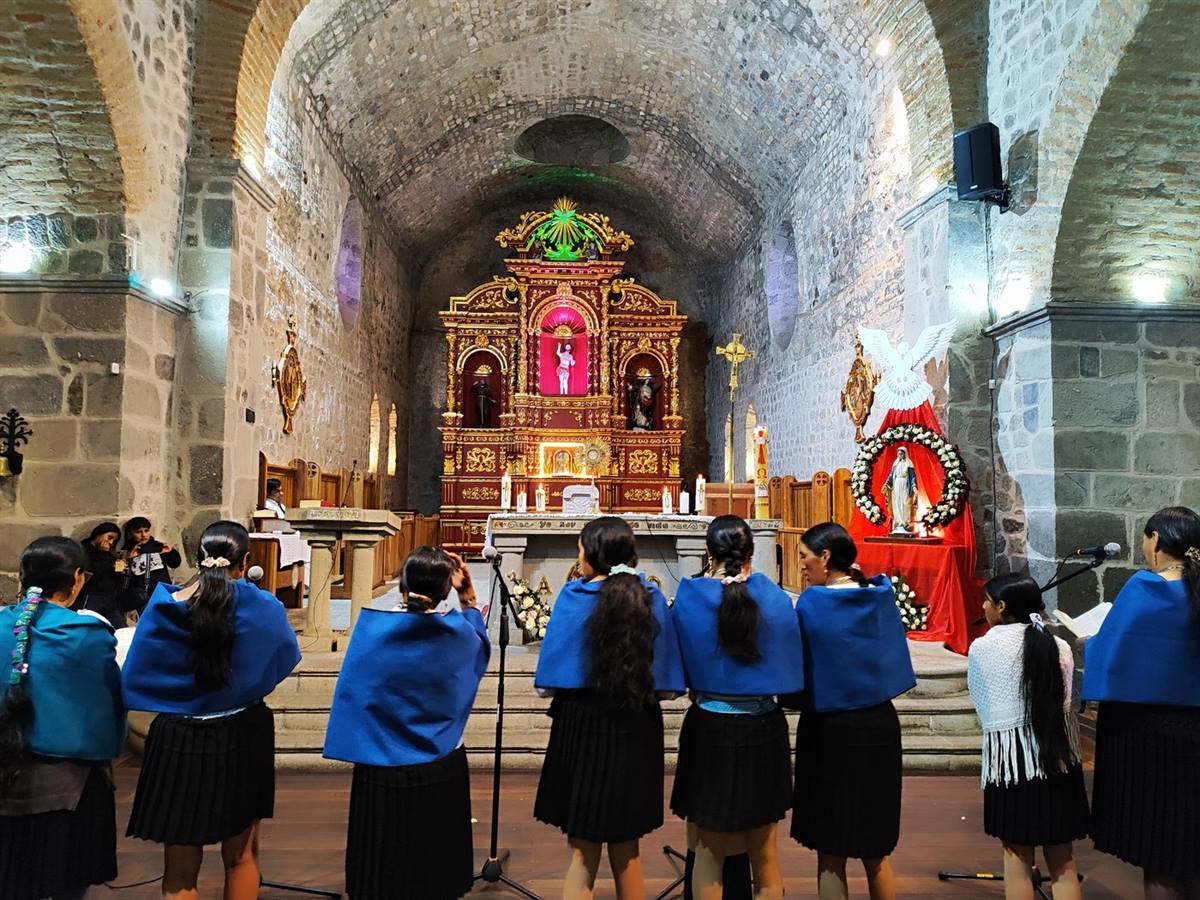 Coro con vestimenta tradicional cantando en Pentecostés