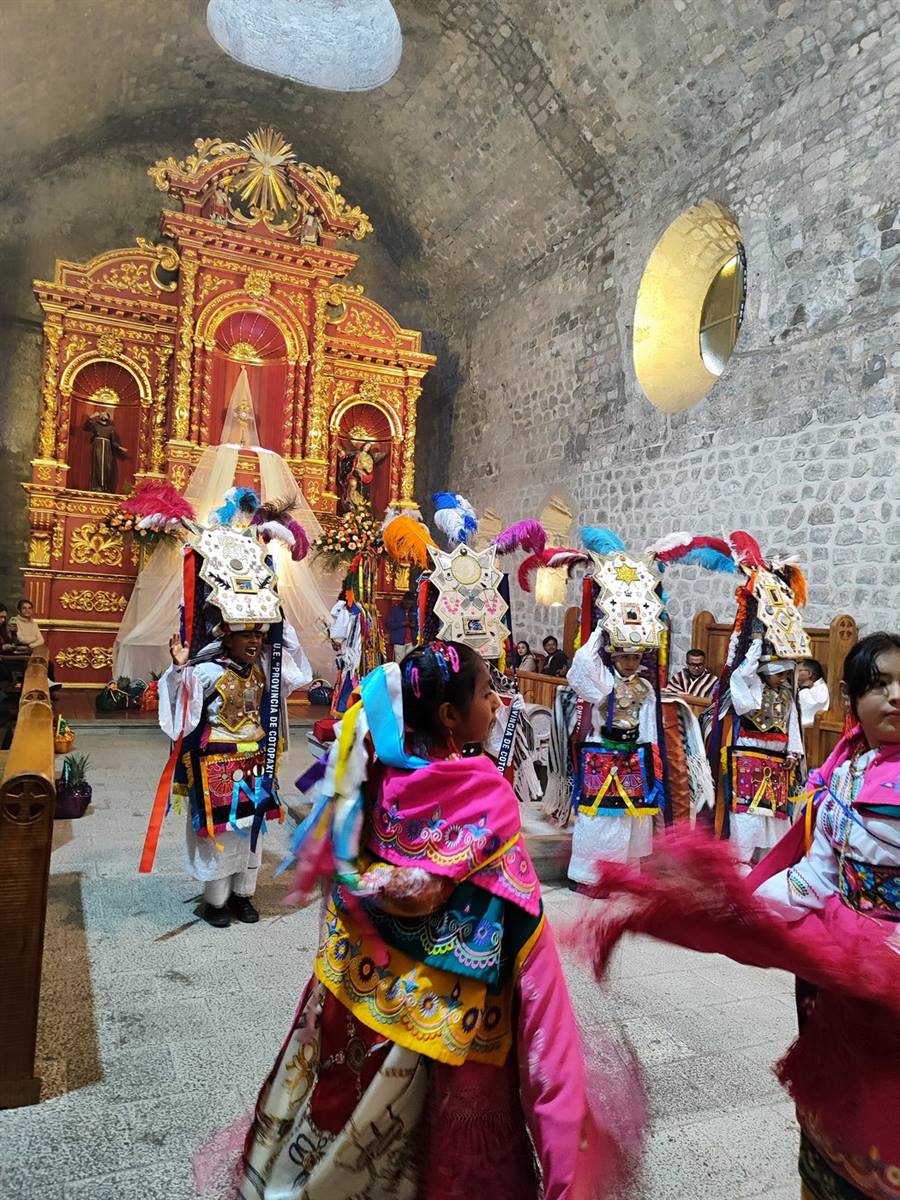 Danzantes de Pujilí bailando dentro del templo junto al retablo