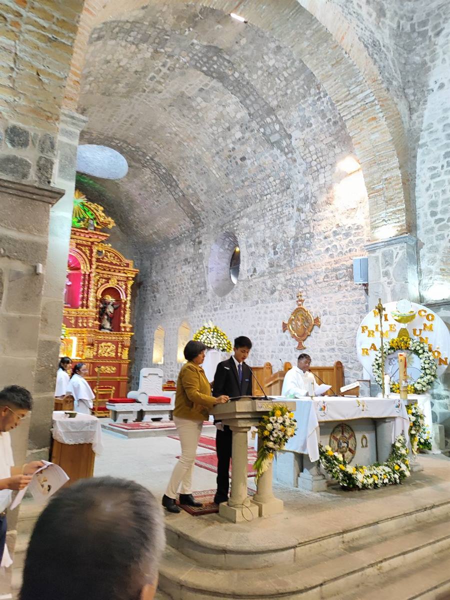 Fieles junto a una cruz conmemorativa en el templo