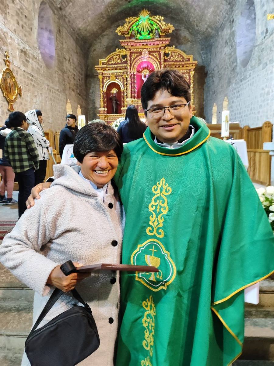 Ministra extraordinaria de la Comunión junto a un sacerdote