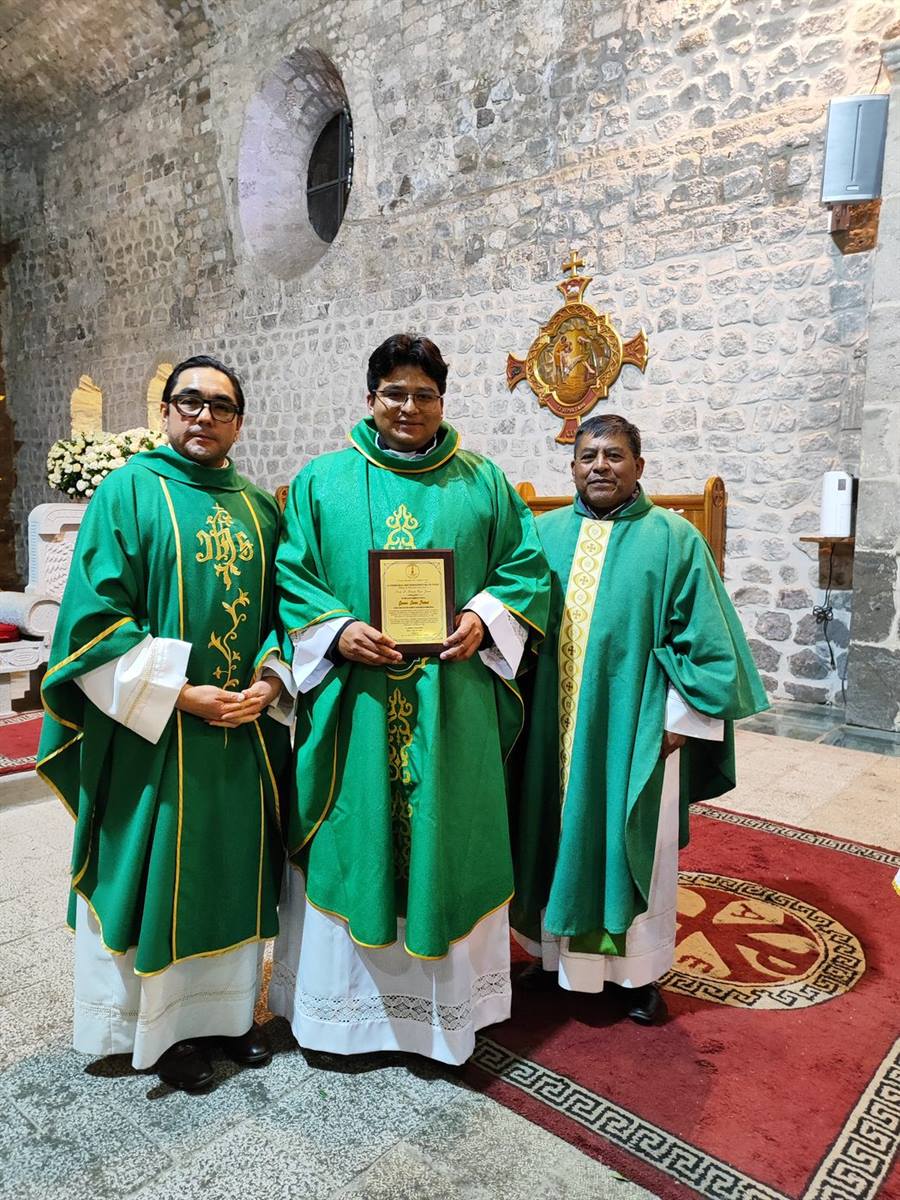 Sacerdotes en el templo, con un reconocimiento entregado por la parroquia